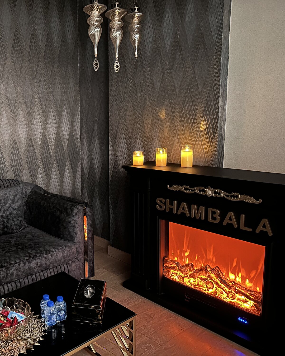 The hearth in the Shambala relaxation lounge, candles lit along the mantel
