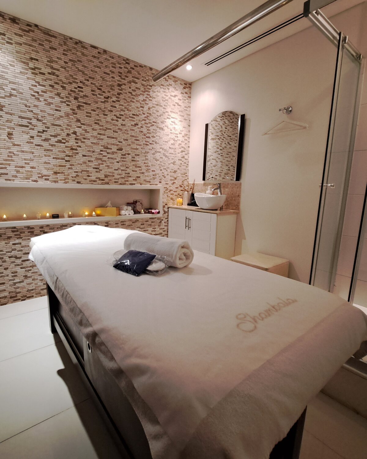 A Shambala treatment room, the bed made and the candle niche lit